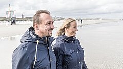 Man and woman on Juist beach looking at the sea and enjoying the sea air