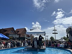 Bild zeigt Stimmung auf dem Kurplatz auf Juist beim Juistival mit Schiffchenteich und feiernden Menschen