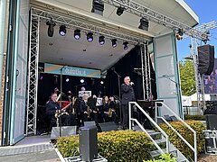Bild zeigt Stimmung auf dem Kurplatz auf Juist beim Juistival feiernden Menschen und Auftritt des Musikzugs der Freiwilligen Feuerwehr Juist