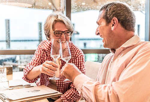 Paar beim Anstoßen bei in einer Bar auf Juist