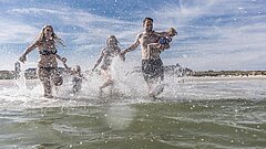 Familie badet in der Nordsee auf Juist