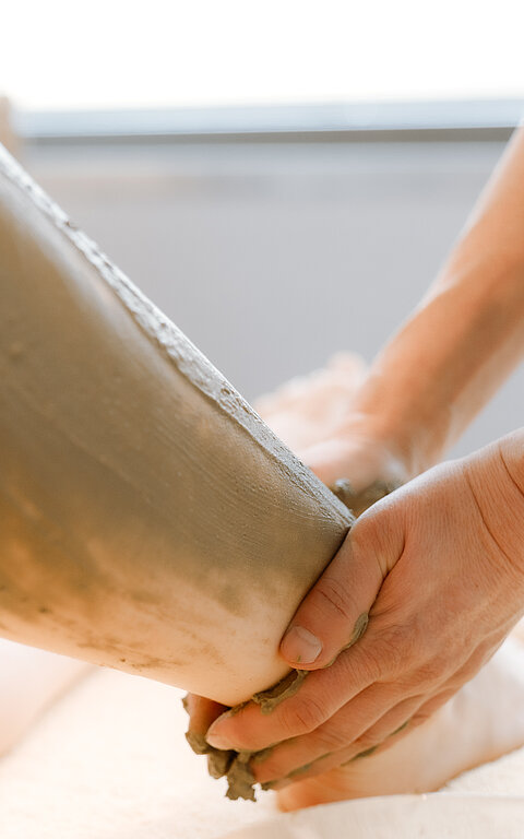 Wellnessangebote auf Juist - Foto zeigt die Hände einer Therapeuting, die Salbe auf das Bein einer Person auf einer Wellnessliege streicht