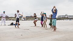 Kinder machen Sport beim Kinderprogramm auf Juist am Strand