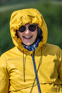Herbsturlaub auf Juist - Frau in einer gelben Regenjacke bei Sonnenschein auf Juist im Herbst