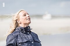 Frau am Strand auf Juist atmet tief ein