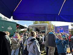Bild zeigt Stimmung auf dem Kurplatz auf Juist beim Juistival feiernden Menschen mit Sicht auf die Bühne über Menschen