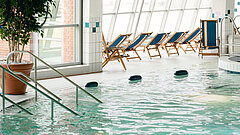 Schwimmbad auf Juist - Bild zeigt Meerwassererlebnisbad im TöwerVital auf Juist mit Ruhebereich im oberen Bildteil und menschenleeres Becken im Vordergrund