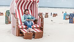 Frau in einem Strandkorb auf Juist am Hauptbadestrand