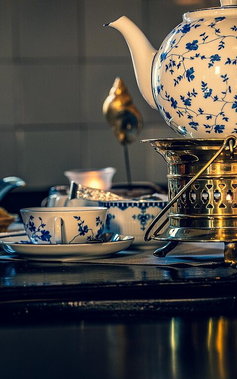 Teekanne mit ostfriesischem Muster auf einem Stövchen in einem Café auf Juist