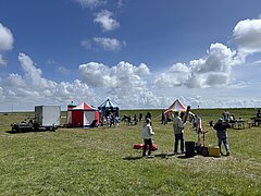 Bild zeigt Kinderprogramm beim Juistival - Musikfestival auf Juist - auf der Wiese zwischen Deich und Hafen mit verschiedenen bunten Attraktionen und Kindern in Action