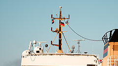 Anreise auf die Insel Juist - Bild zeigt Masten und Oberdeck einer Inselfähre im Hafen auf Juist