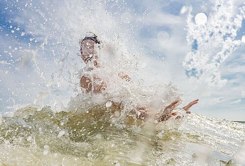 Aufspritzende Gischt bei einer Welle auf Juist