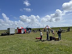 Bild zeigt Kinderprogramm beim Juistival - Musikfestival auf Juist - auf der Wiese zwischen Deich und Hafen mit verschiedenen bunten Attraktionen und Kindern in Action