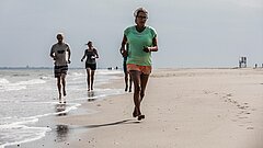 Joggen an der Wasserkante beim Strandsport auf Juist