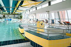 Schwimmbad auf Juist - Bild zeigt Meerwassererlebnisbad im TöwerVital mit Blick über das Schwimmbecken, im Vordergrund ein Boot als Kindeattraktion