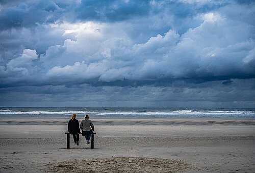 Zwei Personen auf einer Bank am Strand auf Juist