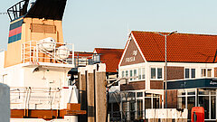 Anreise auf die Insel Juist - Bild zeigt Teil einer Inselfähre sowie das Hafenbetriebsgebäude