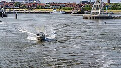 Anreise nach Juist mit der Schnellschiffen des Töwerland Express oder des Inselexpress mit Blick auf den Hafen bei Hochwasser mit Seezeichen und Juister Skyline im Hintergrund